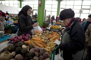 A man purchases vegetables at a market in Bucharest, Romania, on Thursday, Jan. 14, 2010. Romanias credit rating outlook may be raised as Parliament prepares to pass the 2010 budget this week in a move that would unfreeze a $30 billion bailout loan. Photographer: Davin Ellicson/Bloomberg